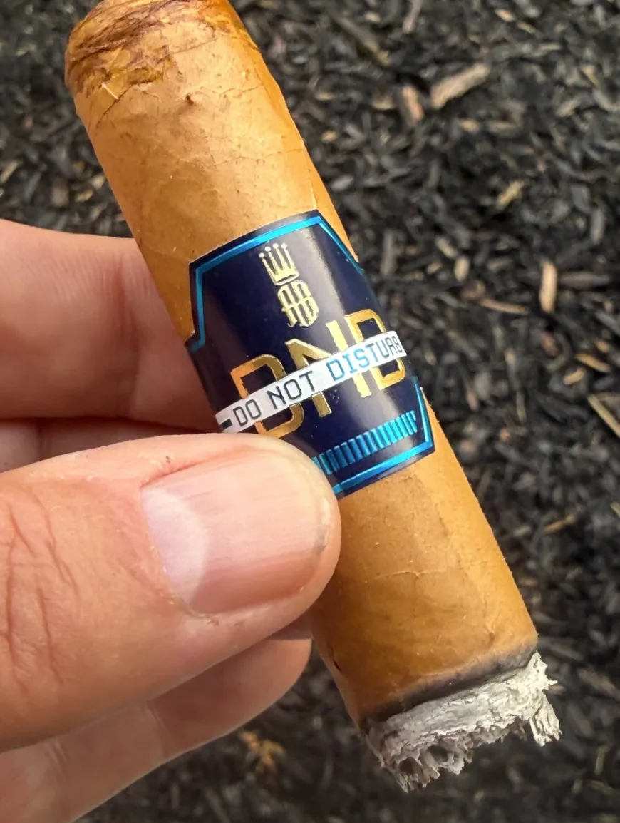 The Alec Bradley Do Not Disturb held on the porch, DND band and Do Not Disturb ribbon in focus
