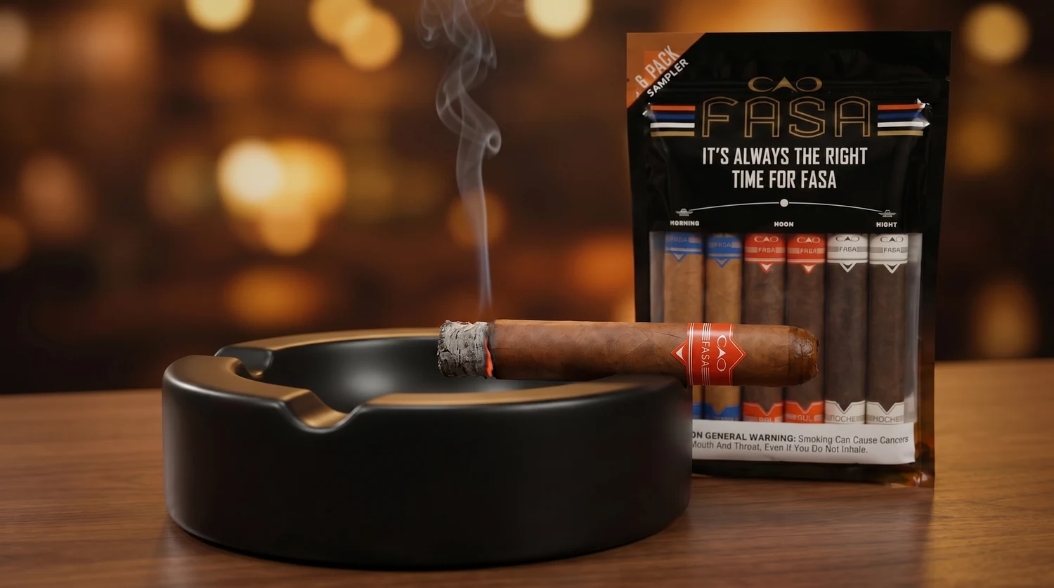 A CAO FASA cigar resting in a large ashtray with a slow curl of smoke off the foot, the resealable fresh pack beside it