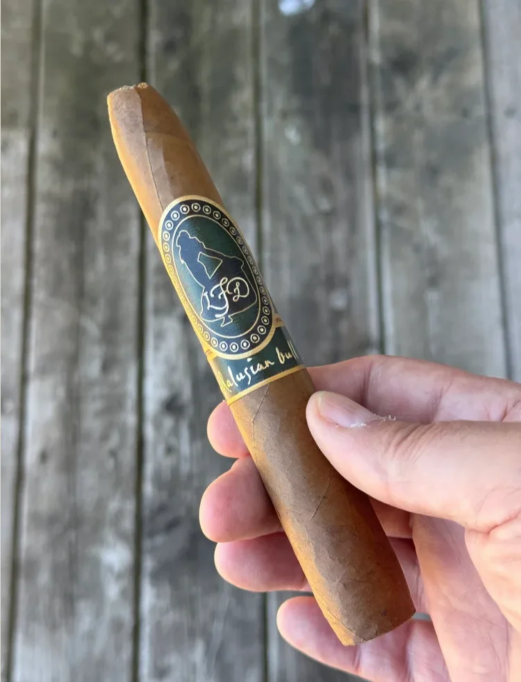 Hand holding the La Flor Dominicana Andalusian Bull figurado showing the tapered head