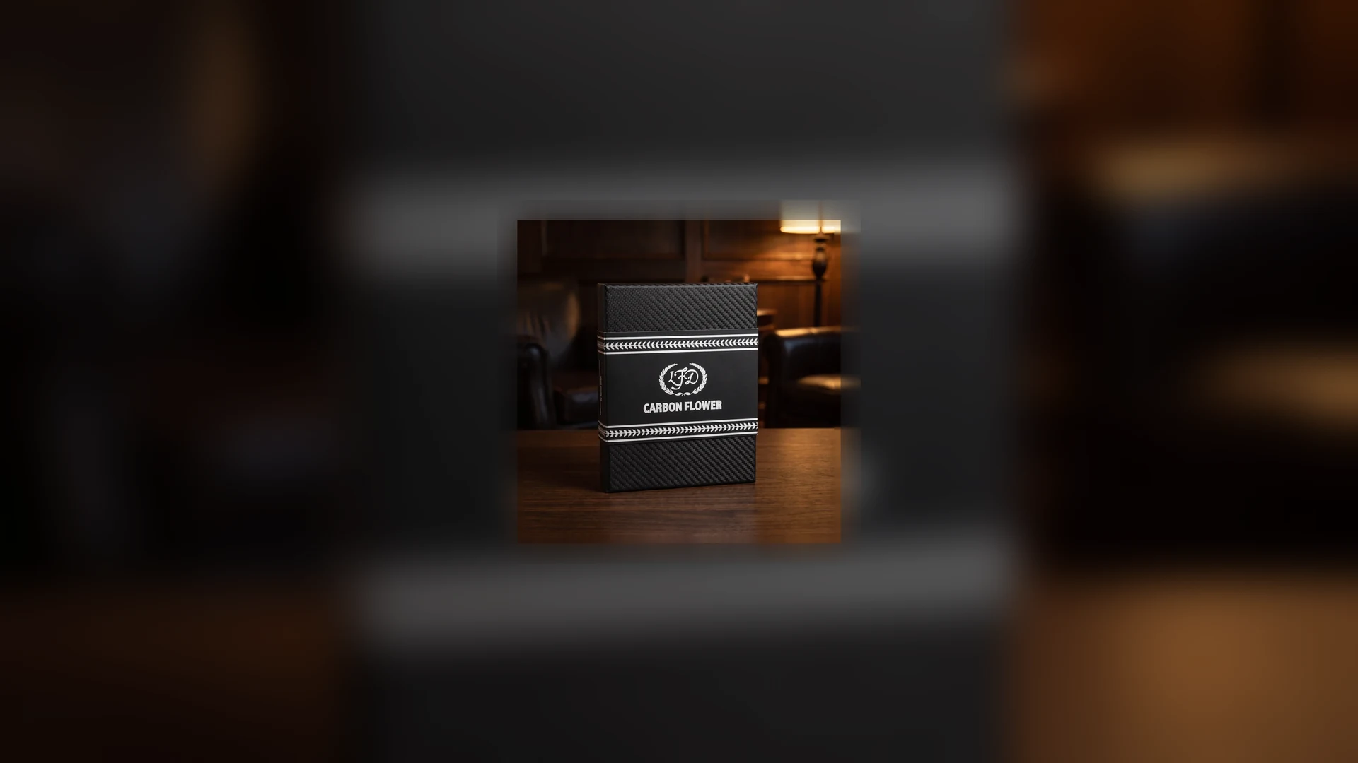 La Flor Dominicana Carbon Flower carbon fibre cigar case, glossy black twill weave with white laurel braid bands and a silver five-petal flower medallion