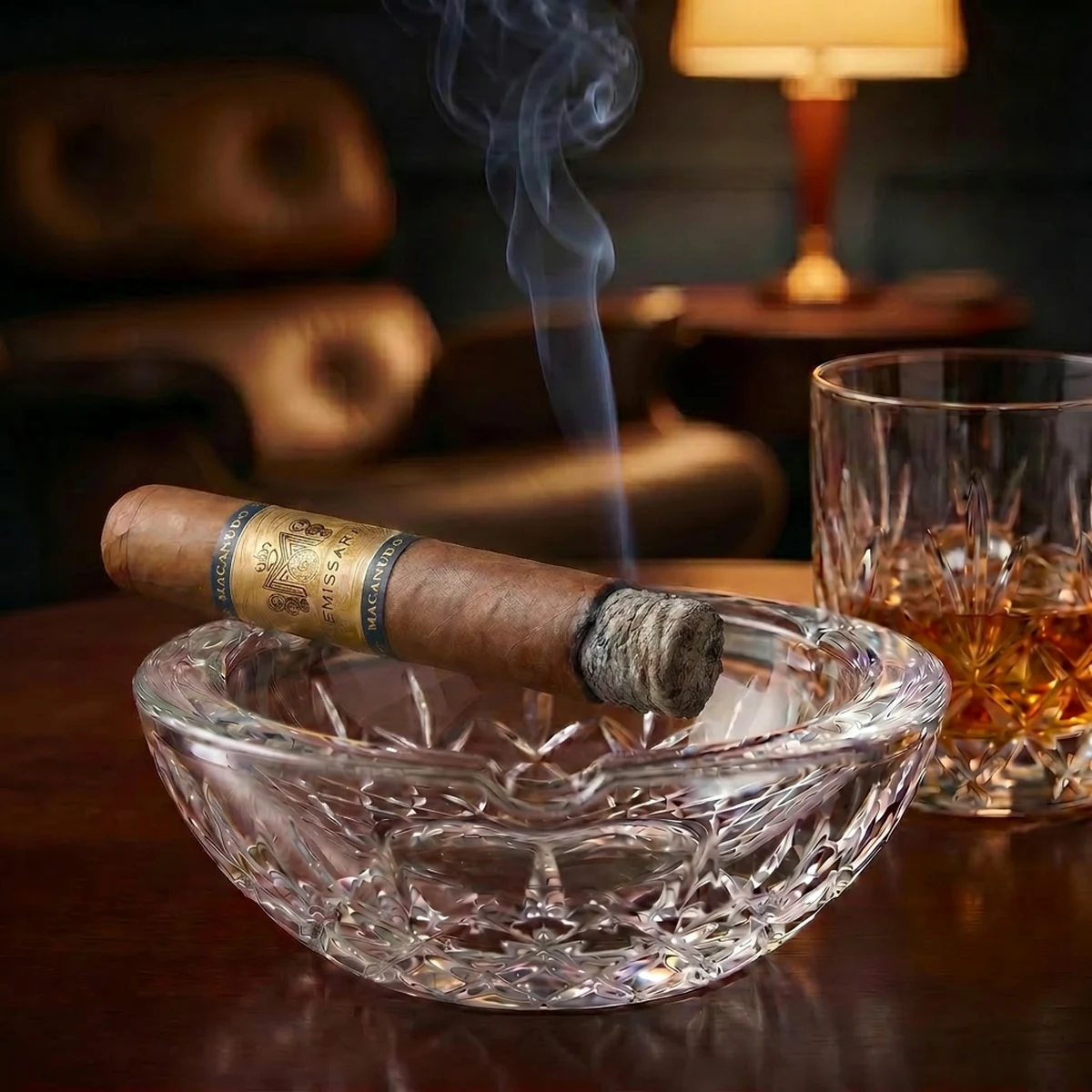 MACANUDO EMISSARY FRANCE ROBUSTO 5×52 resting in a crystal ashtray beside a whiskey glass