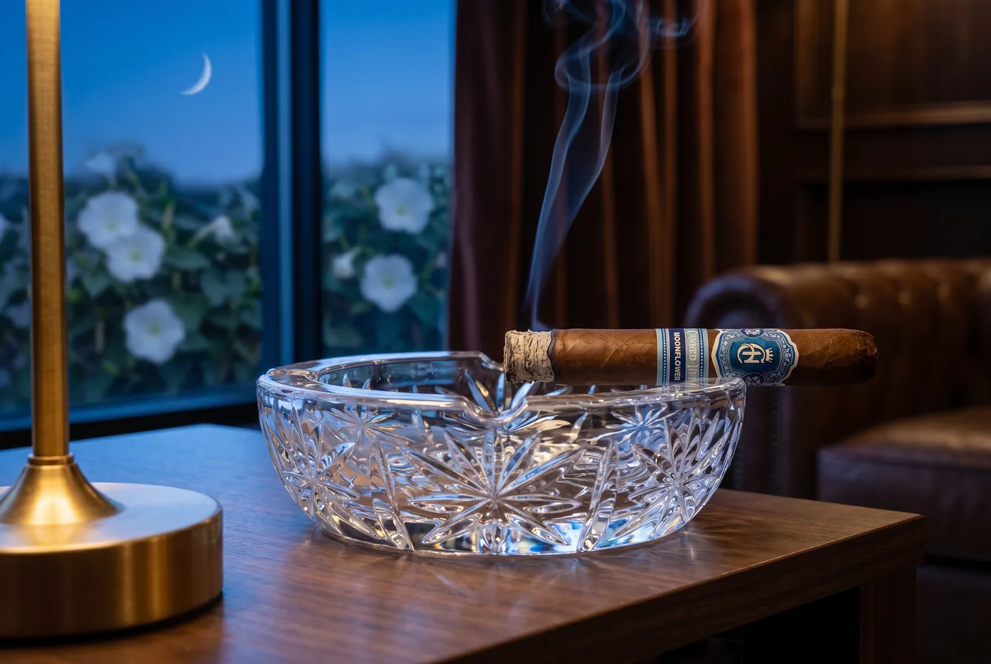 Lit Crowned Heads Moonflower resting on a cut-crystal ashtray at night, smoke rising from the foot