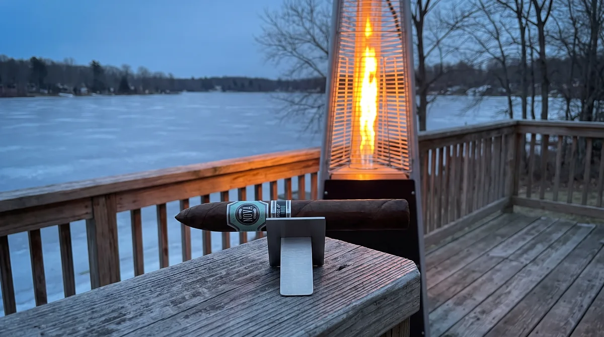 PLATINUM NOVA TRAPPIST 1G TORPEDO 7&frac14;&times;54 on a porch table with a patio heater and frozen lake behind
