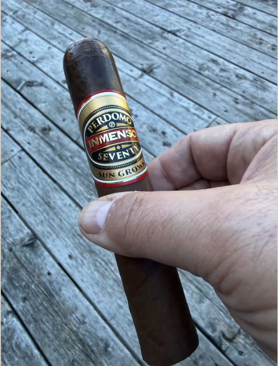 PERDOMO INMENSO SEVENTY SUN GROWN EPICURE 6×70 held in hand on the porch