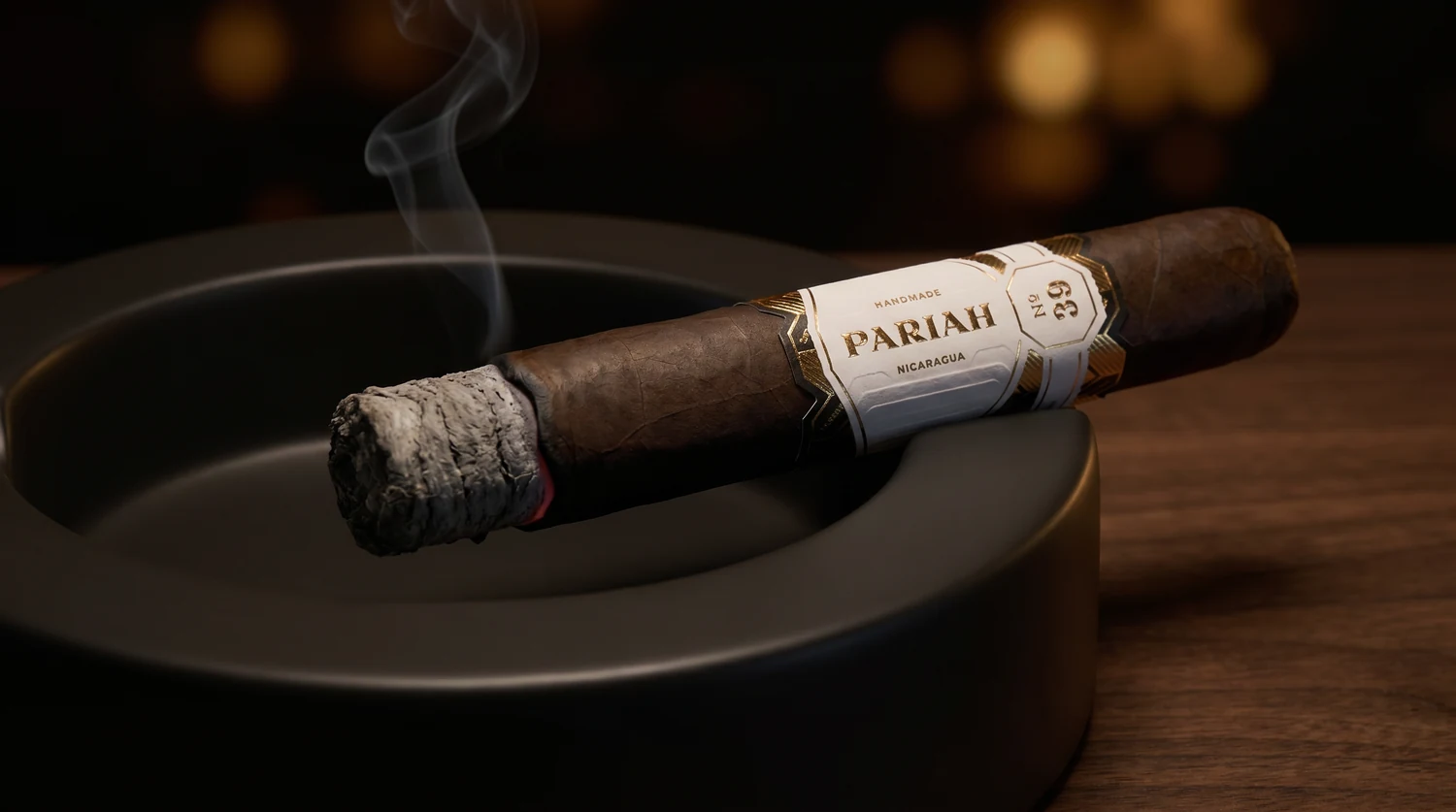 A single Pariah No. 39 box-pressed super toro resting in an ashtray with a slow curl of smoke off the foot