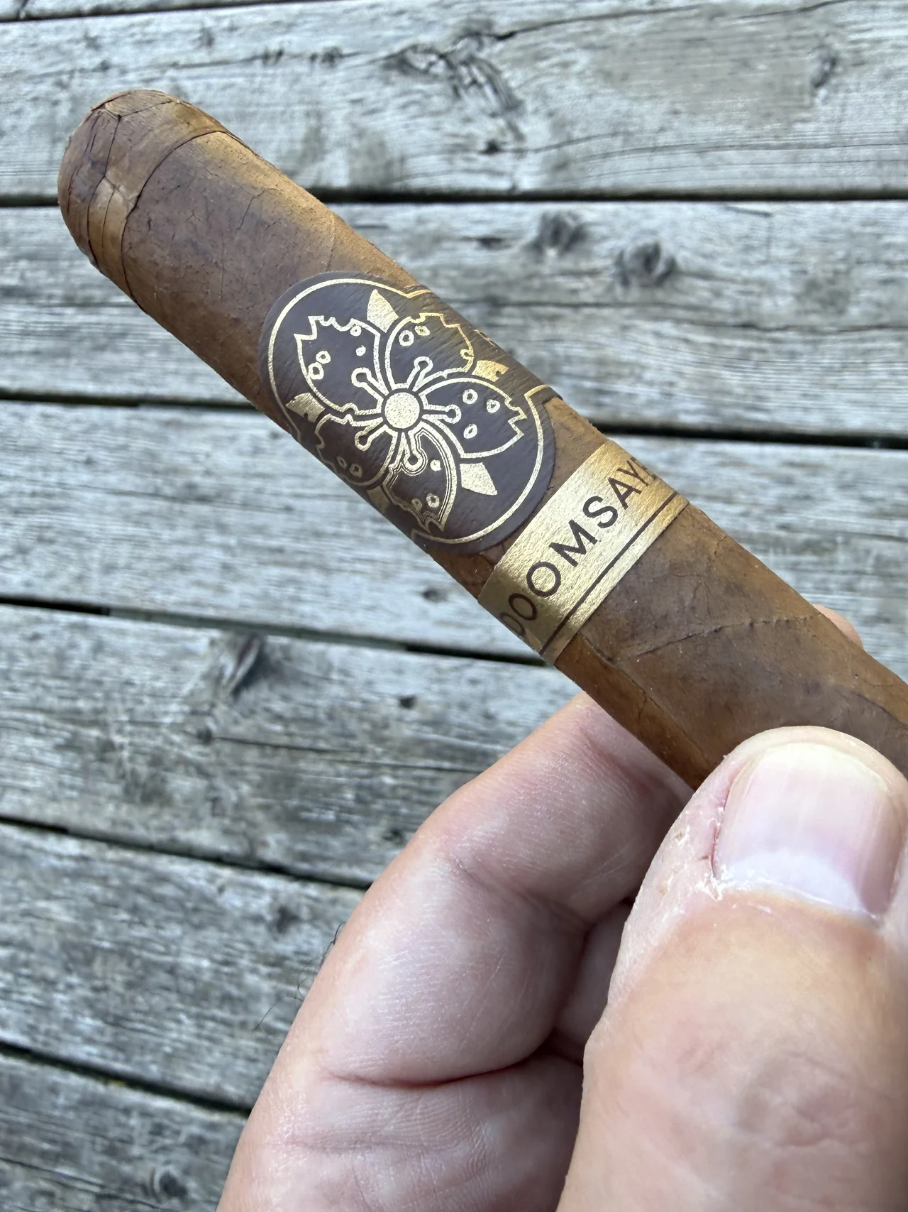 ROOM101 DOOMSAYER 6&times;55 held on the porch, medium-brown Habano wrapper and sakura band