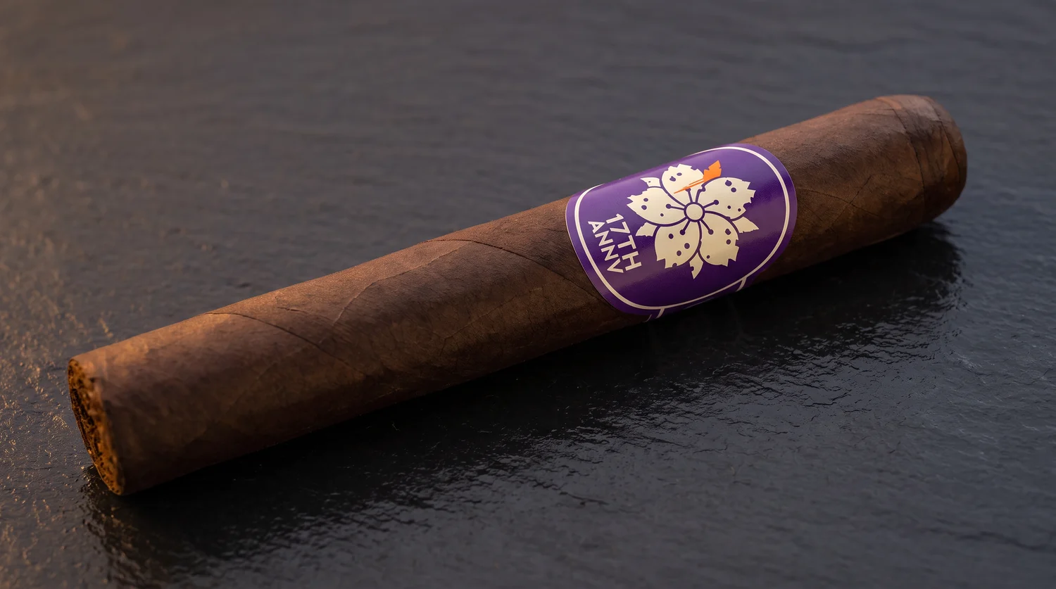Single Room101 17th Anniversary toro on dark slate, dark maduro wrapper and the tall purple oval band with a cream cherry blossom above 17TH ANNV