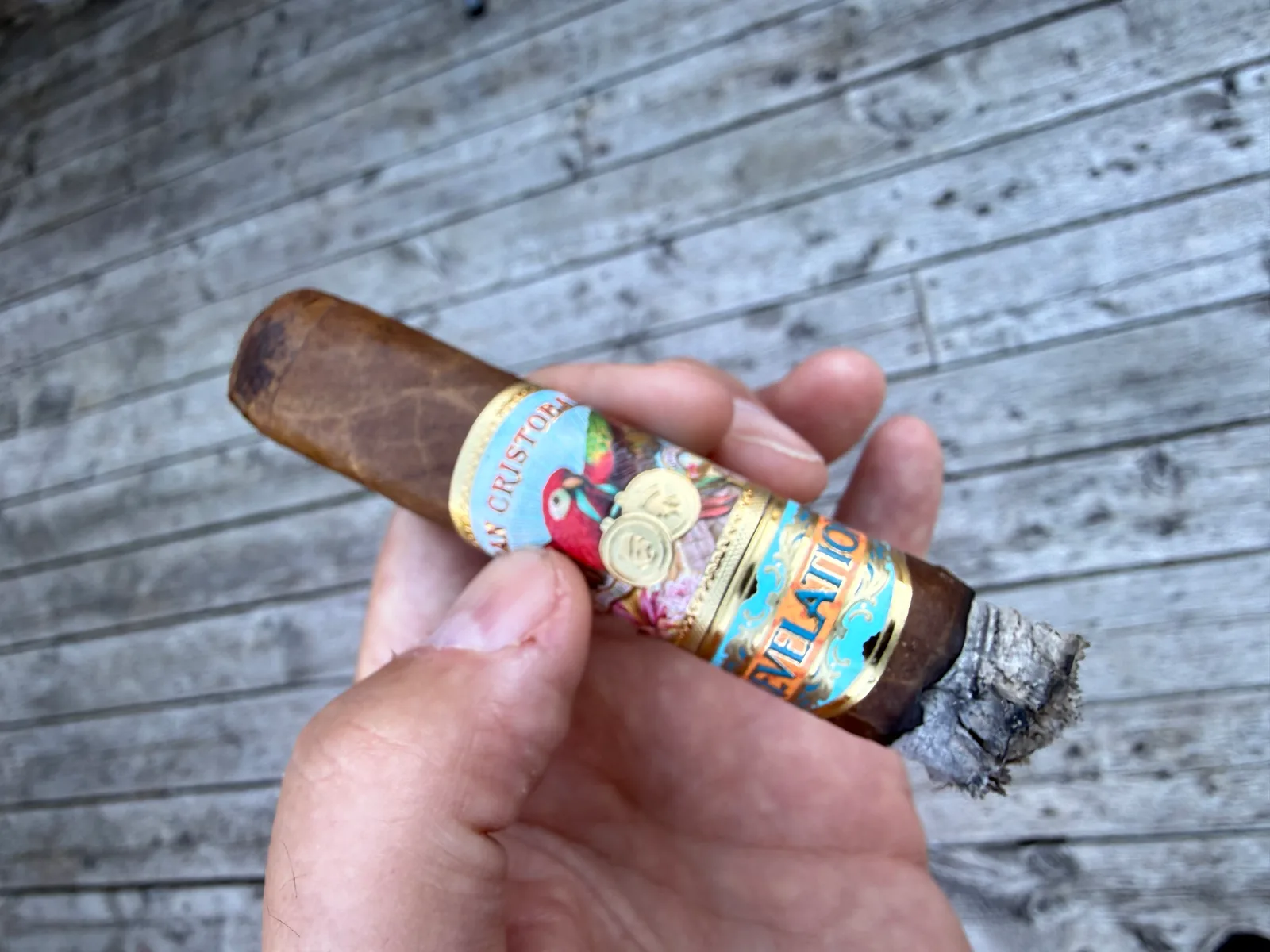 Holding the lit San Crist&oacute;bal Revelation Legend cigar on the porch