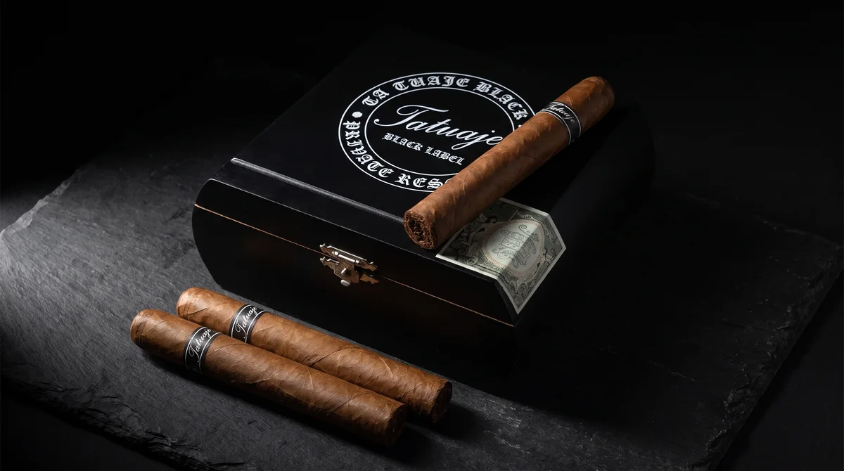 Tatuaje Black Label box with cigars fanned on dark slate