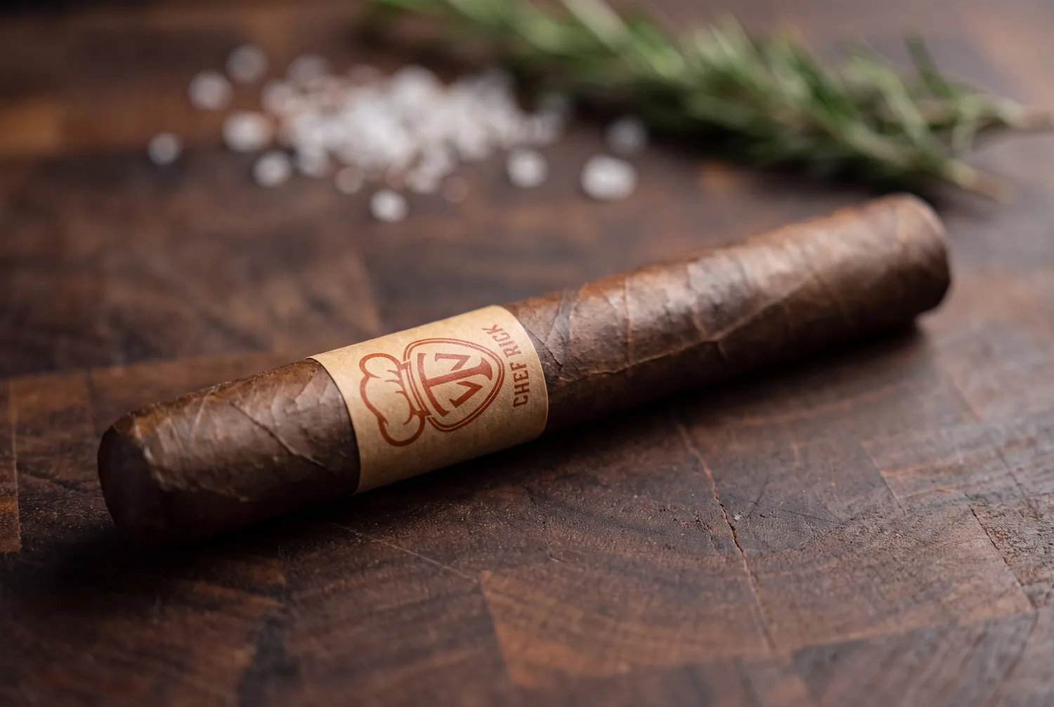 The West Tampa Chef Rick toro laid on a dark butcher-block surface, its Habano 2000 wrapper oiled and reddish brown