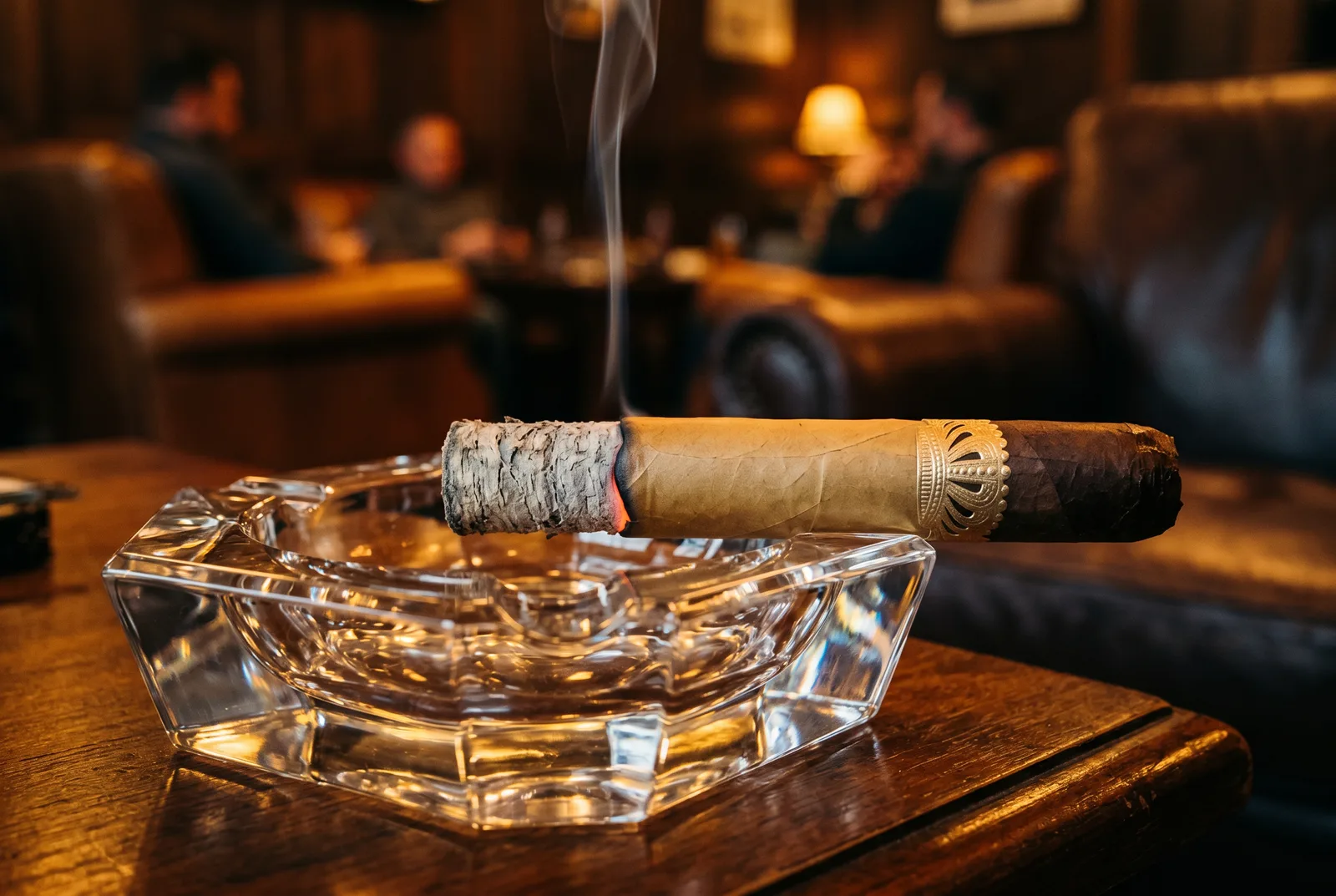 Lit Sobremesa Tapa Negra resting in a crystal ashtray with smoke rising from the burn line where the ash begins